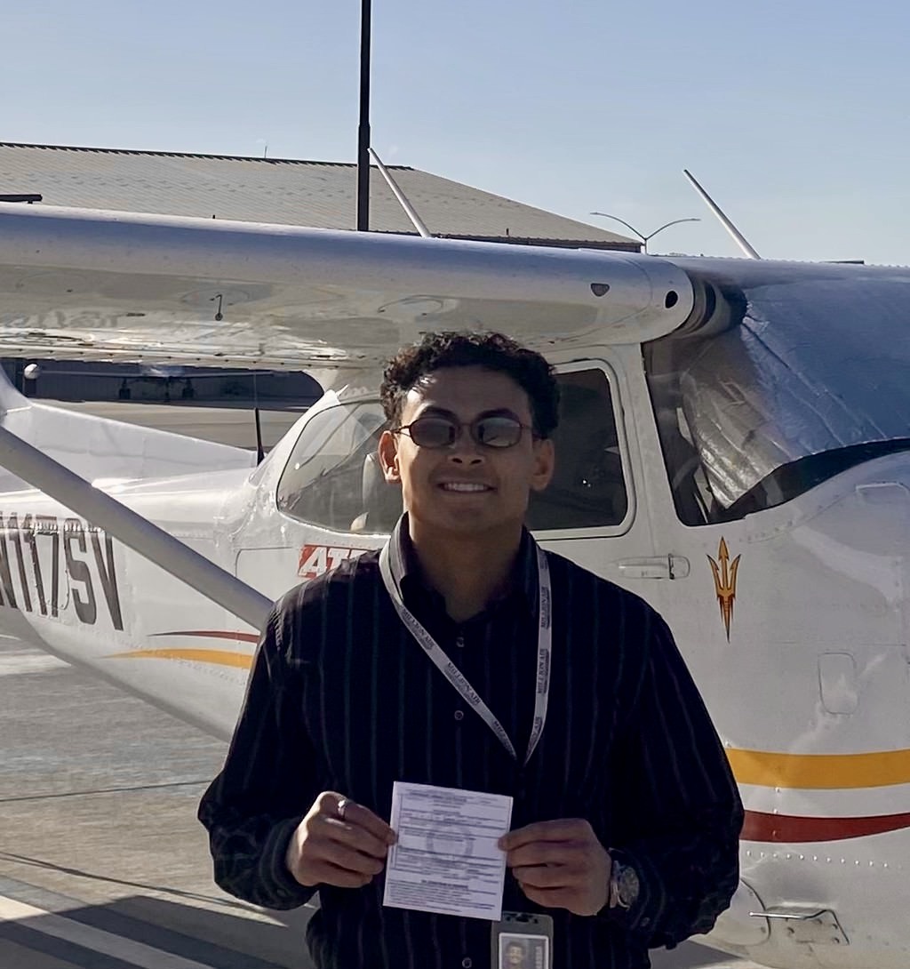 Student receiving pilot certificate from Eron LeBlanc